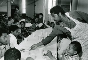 2-Charles-Bursey-hands-plate-of-food-to-a-child-seated-at-Free-Breakfast-Program.-Photo-courtesy-of-Pirkle-Jones-and-Ruth-Marion-Baruch.PJ_v1
