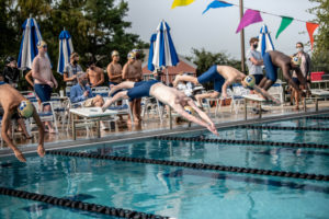 Jesuit Swimmers diving at the beginning of the race