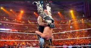 The Undertaker, the wrestler who is holding his opponent upside down, finisher move is the Tombstone Piledriver