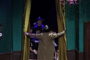 Inspector Carter peeks outside the window to see the weather but the whole stage crew is there, thus increasing the errors in the play